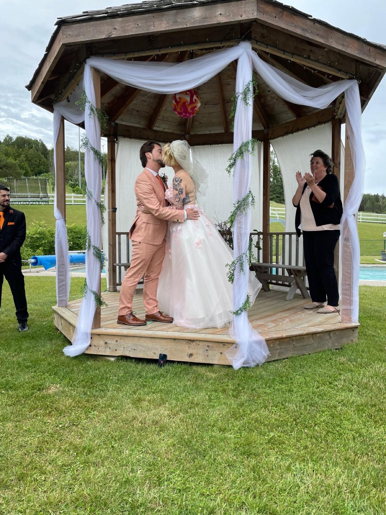 Couple kissing under the string-lit gazebo