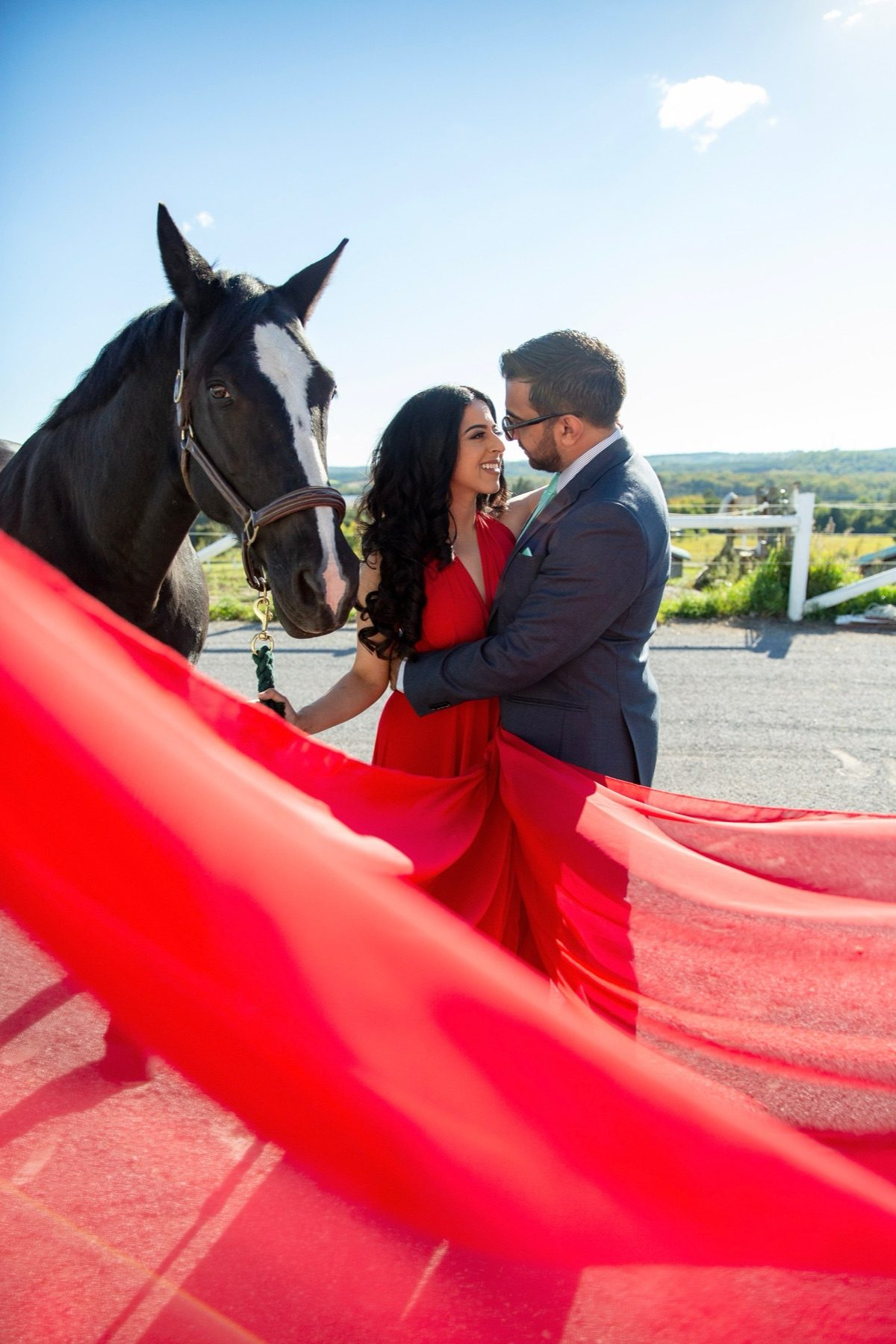 Couple laughing with horse, red gown