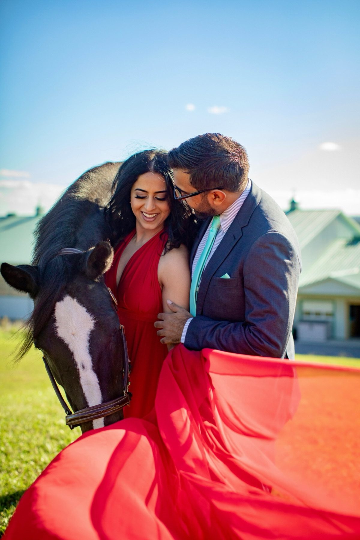 Couple with horse against the barn