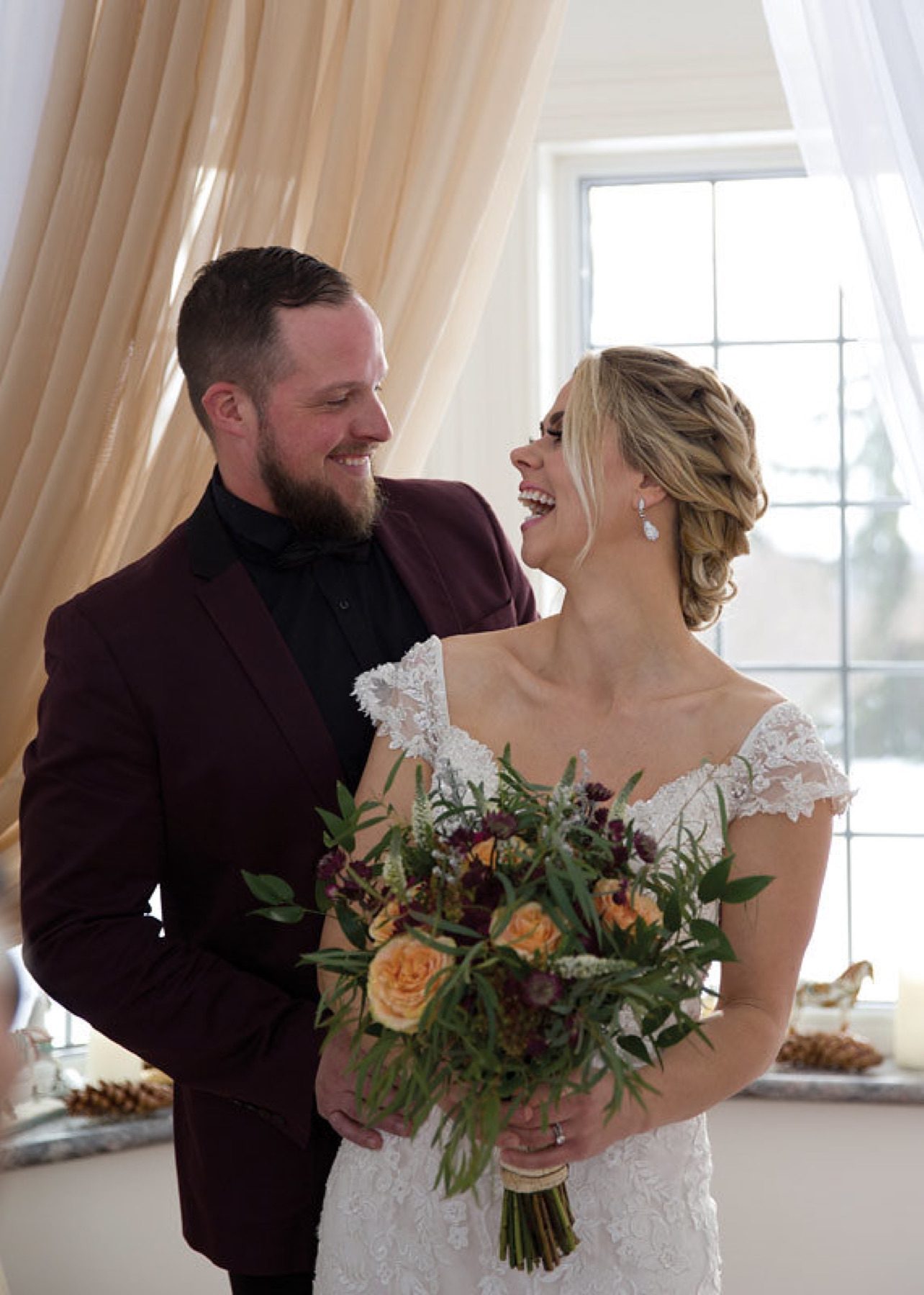 Couple laughing together holding a bouquet