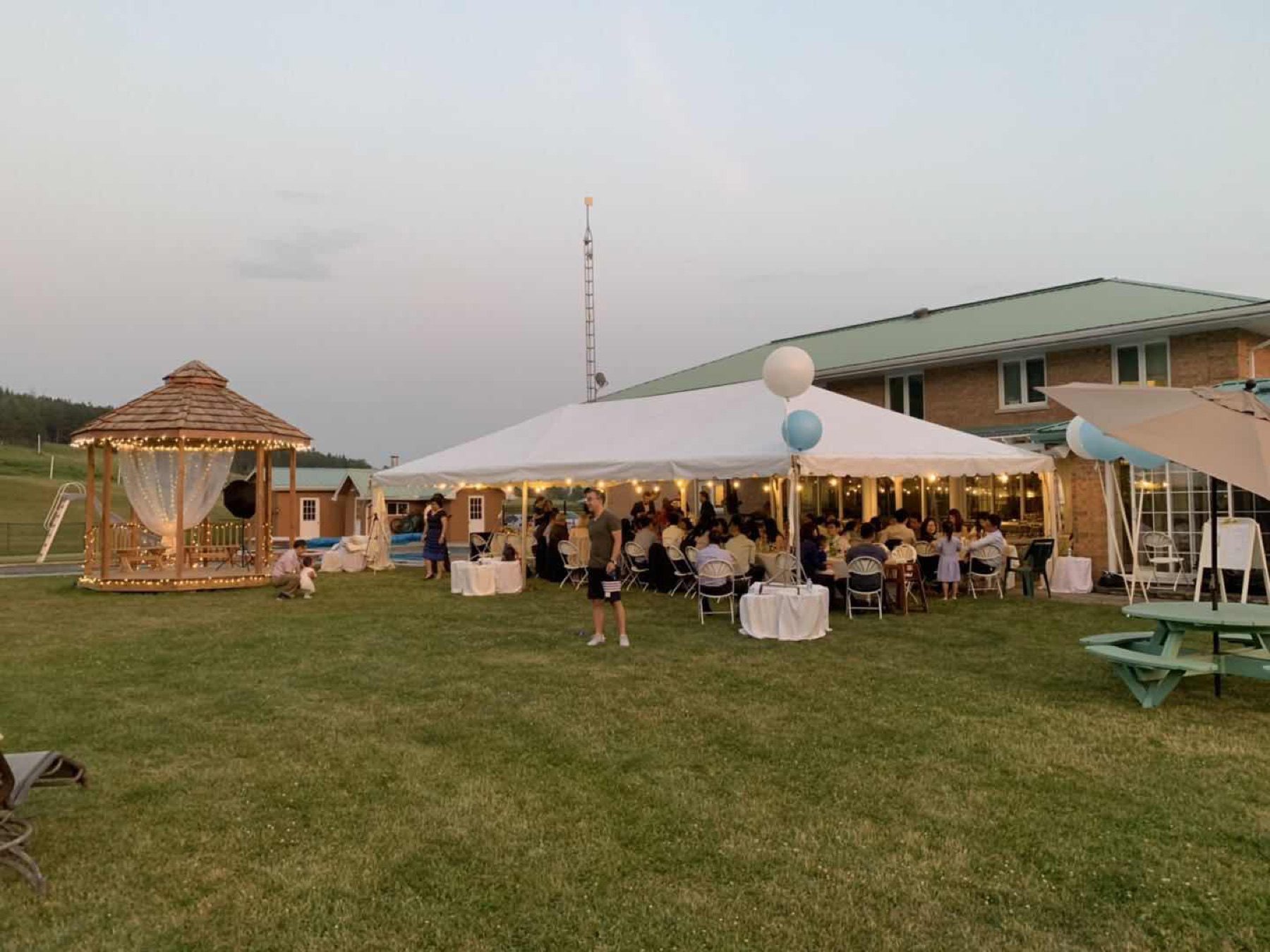 Tented reception with guests seated at dusk