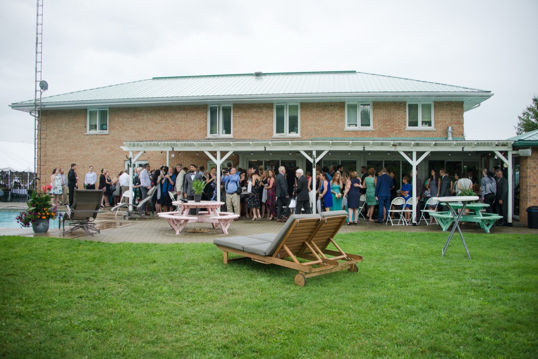 Large crowd of guests gathered on the covered patio