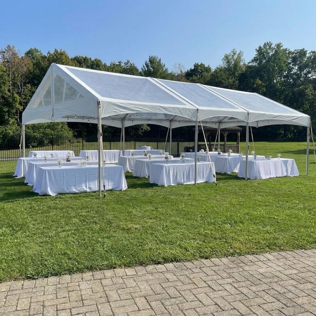 Large reception tent set up on the lawn with long banquet tables
